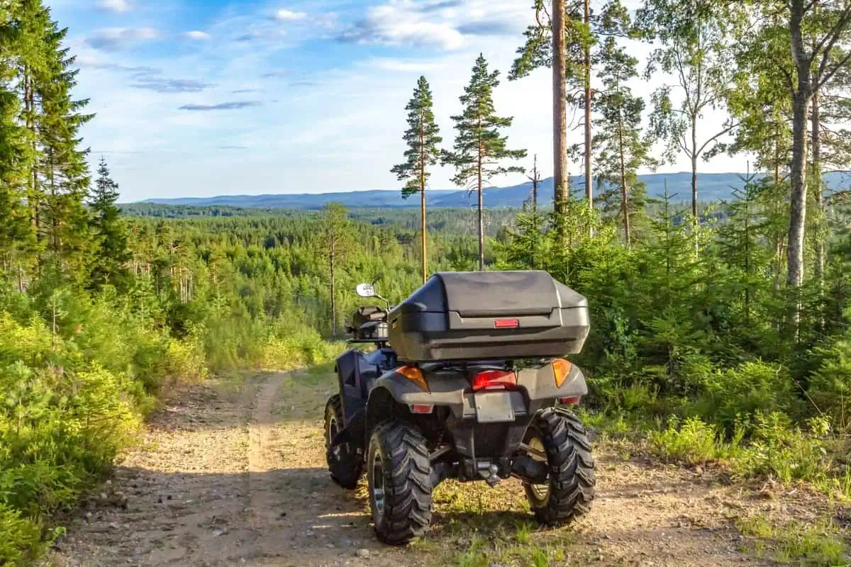 ATV på grusvei i norsk skog, klar for terrengkjøring